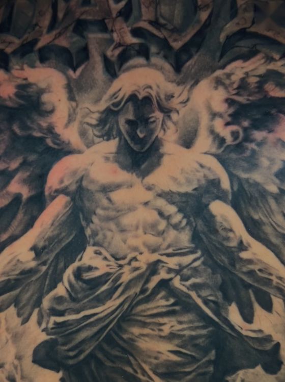 Black and grey angelic figure tattoo with spread wings