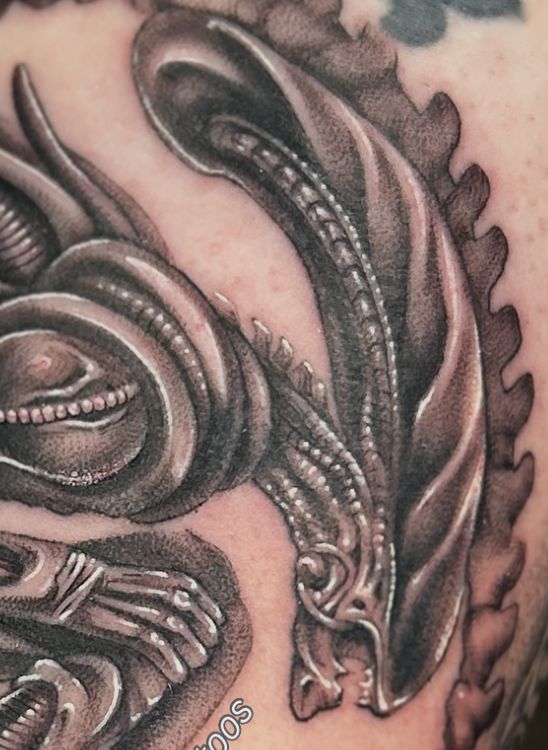 Black and grey biomechanical creature tattoo