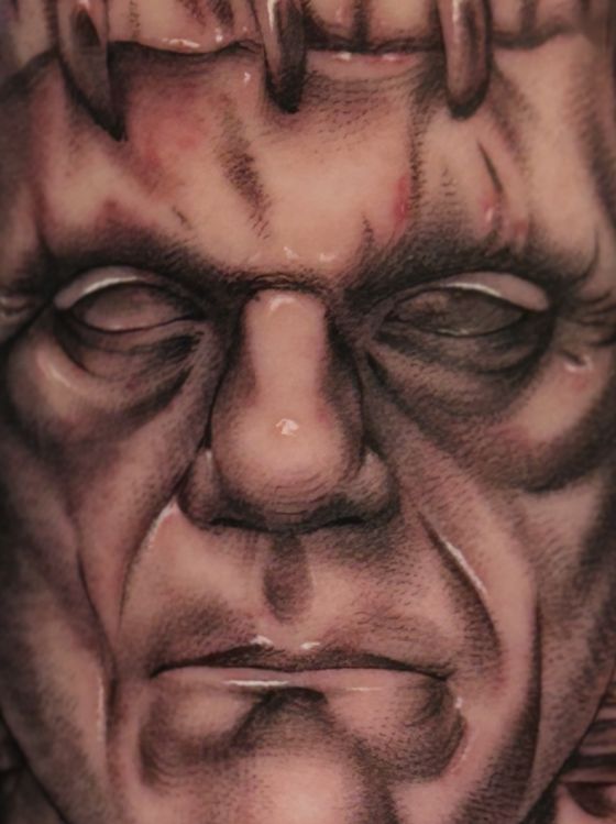 Black and grey stitched monster portrait tattoo
