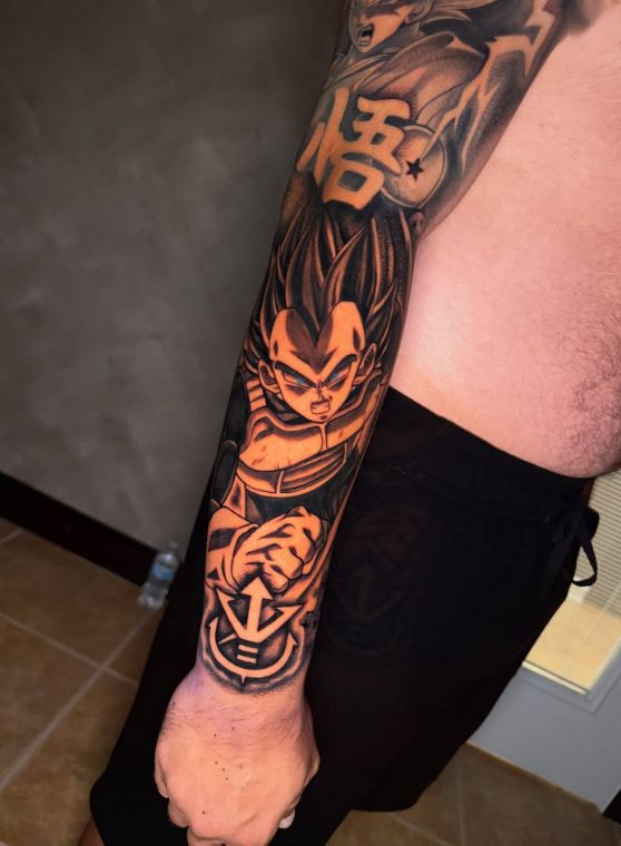 Black and orange anime warrior forearm sleeve tattoo