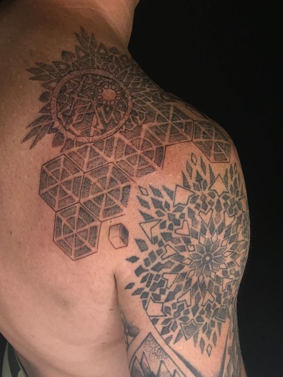 Geometric and mandala dotwork tattoo across a shoulder