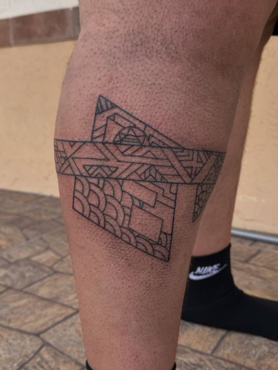 Geometric linework tattoo band on a calf